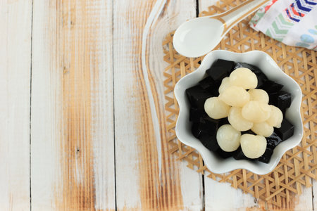 Top View Chaokuai or Suong Sao, Black Grass Jelly Mesona Chinensis, Vegetable Jelly, Eaten with Sugar in Bowl with Fruits on Topの写真素材