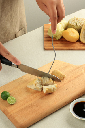 Female Hand Slicing Baso Tahu Siomay Bandung, Ready to Eatの写真素材