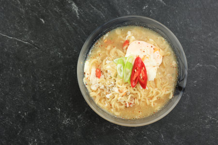 Top View Mie Rebus, Boiled Spicy Indonesian Instant Noodle with Poached Egg and Chilli. Copy Space...