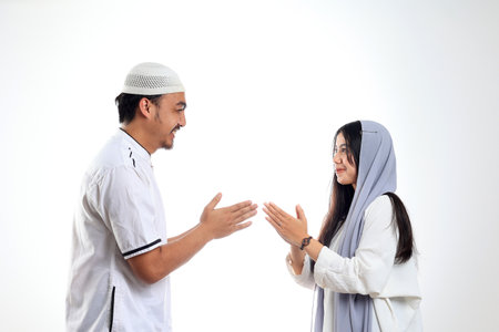 Asian Couple Forgiving Each Other by Giving Greets Hand During Eid Mubarak Celebration, Isolated on White. Concept Salaman Lebaranの写真素材