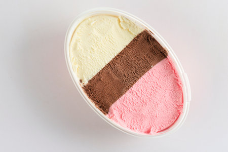 Neapolitan Ice Cream or Harlequin Es Krim on Oval Bucket Packaging. Isolated on White, Top Viewの写真素材