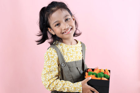 Smiling Indonesian Asian Girl with Her Healthy School Lunchboxの写真素材