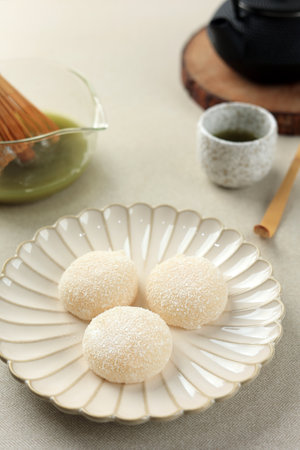 White Mochi Coated with Dried Coconut Flakes, Served with Green Teaの写真素材