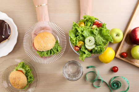 Top View Female hand with Burger and Salad, Diet Conceptの写真素材