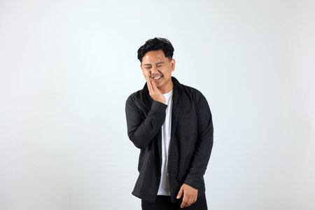 Young Asian Man Standing Over White Background Touching Mouth with His Hand,  Painful Expression...