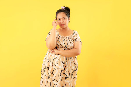 Indonesian Woman with Finger on Head, Think and Idea. Young Woman Wearing Daily Dressの写真素材