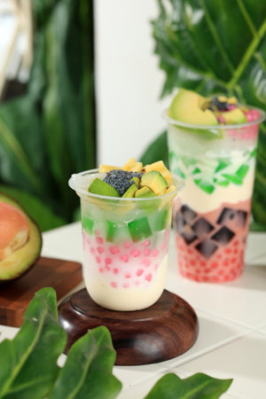 Es Teler Sultan in Tall Plastic Cup, Indonesian Traditional Mix Fruit Popular Street Food Contain of Sagoo Pearl, Avocado, Jackfruit, Young Coconut, and Syrupの写真素材