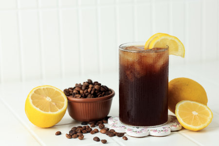 Coffee with Tonic in a Tall Glass with Ice and Lemon on White Table Background. Trendy Summer Craft Refreshing Drink.の写真素材