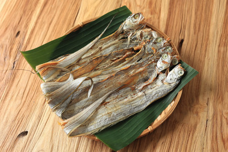 Ikan Asin Layur Tipis or Dried Thin Salt Fish, Sundried Beltfish Long Ribbon Shaped Fish on Wooden Tableの写真素材