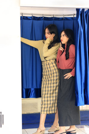 Two Young  Asian Girl doing Photoshoot at the Blue Photobooth Stand with Silly Face Expressionの写真素材