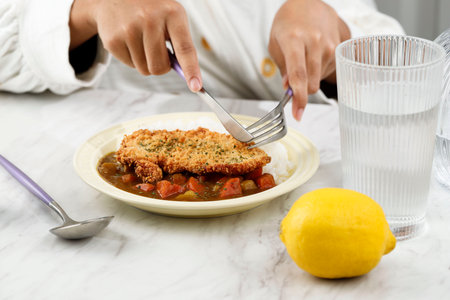 Female Hand Holding Knife and Fork Eating Tonkatsu Curry