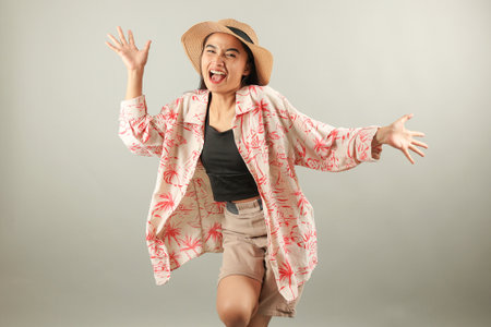 Positive Asian Female Tourist Wearing Summer Holiday Beach Shirt and Hat Feels Happinessの写真素材