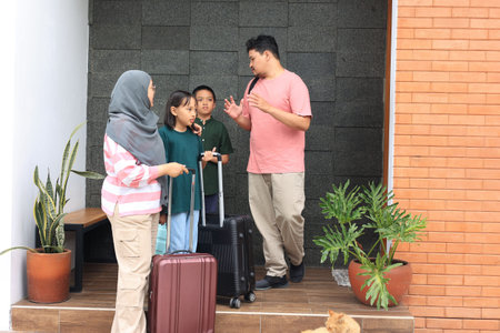 Muslim Indonesian Family Preparing Mudik Lebaran, Pulang Kampung with Luggage in front of the House