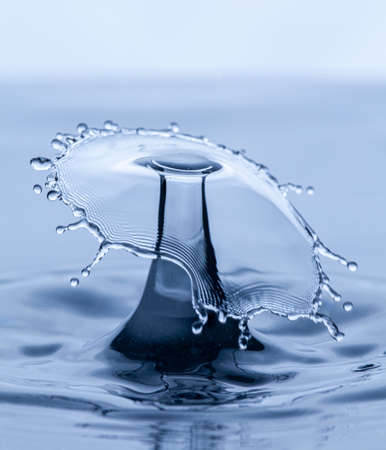 Splash and umbrella on white background. Reflection on the surface of the water.の写真素材
