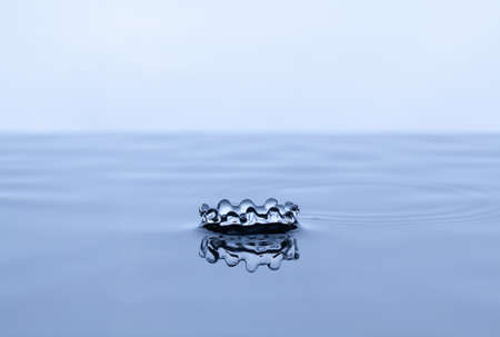 Splash and crown on white background. Reflection on the surface of the water.の写真素材