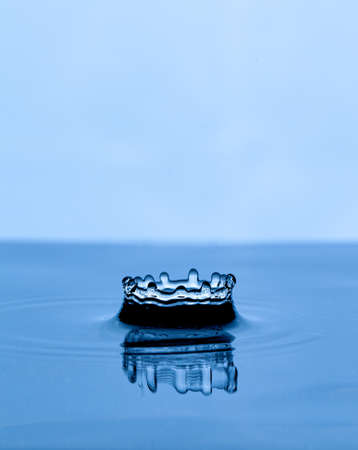Splash and crown on white background. Reflection on the surface of the water.の写真素材