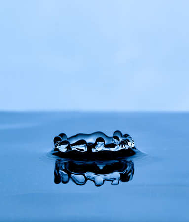 Splash and crown on white background. Reflection on the surface of the water.の写真素材