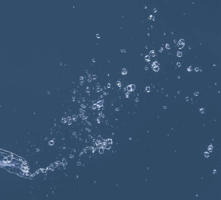 Water splash on a blue background. Reflection on the surface of the water.の写真素材