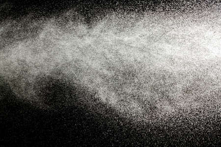 Sprayed water. Small droplets of water in the air. Lots of water drops, isolated on black background.の写真素材