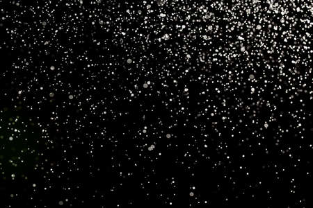 Sprayed water. Small droplets of water in the air. Lots of water drops, isolated on black background.の写真素材