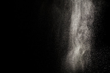 Sprayed water. Small droplets of water in the air. Lots of water drops, isolated on black background.の写真素材