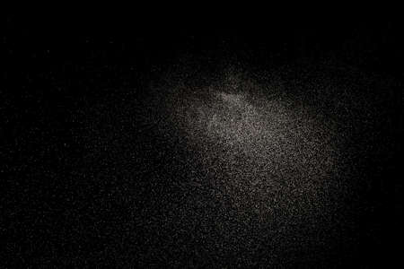 Sprayed water. Small droplets of water in the air. Lots of water drops, isolated on black background.の写真素材