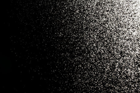 Sprayed water. Small droplets of water in the air. Lots of water drops, isolated on black background.の写真素材