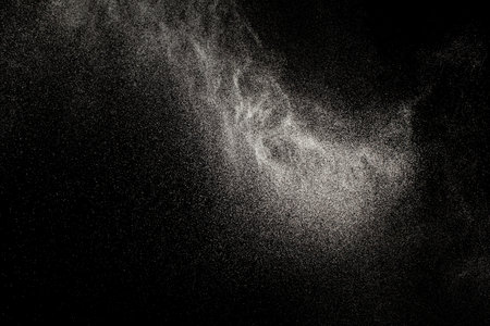 Sprayed water. Small droplets of water in the air. Lots of water drops, isolated on black background.の写真素材