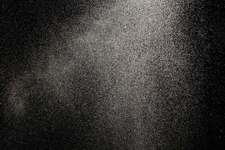Sprayed water. Small droplets of water in the air. Lots of water drops, isolated on black background.の写真素材