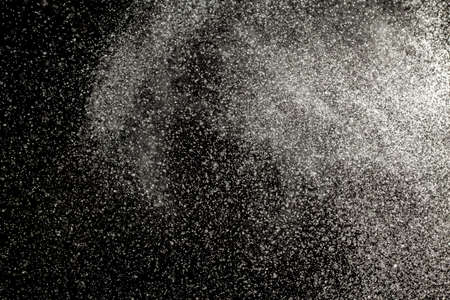 Sprayed water. Small droplets of water in the air. Lots of water drops, isolated on black background.の写真素材