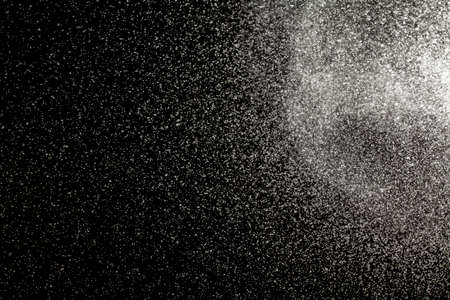 Sprayed water. Small droplets of water in the air. Lots of water drops, isolated on black background.の写真素材