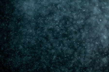 Glowing blue highlights. Wallpaper pattern. Blue sparkling spots. Dust or fog on a black background.の写真素材