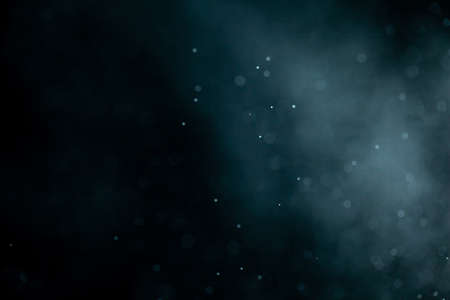 Glowing blue highlights. Wallpaper pattern. Blue sparkling spots. Dust or fog on a black background.の写真素材