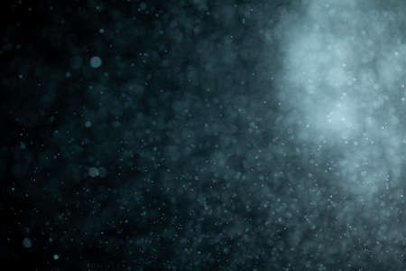 Glowing blue highlights. Wallpaper pattern. Blue sparkling spots. Dust or fog on a black background.の写真素材