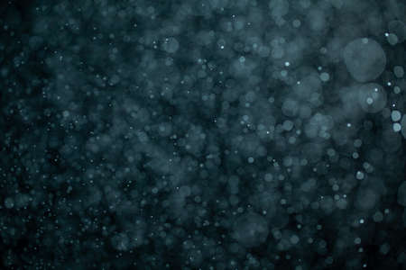 Glowing blue highlights. Wallpaper pattern. Blue sparkling spots. Dust or fog on a black background.の写真素材