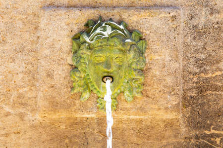 Old fountain with a faceの写真素材