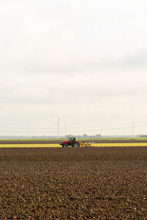Tractor plowing the rich soil of the landの写真素材