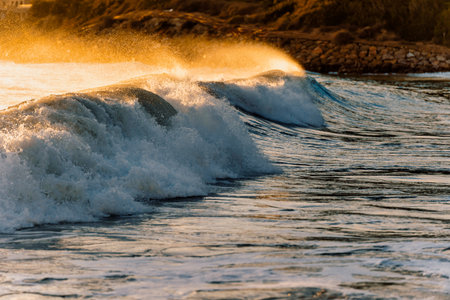 Foamy waves of clean sea rolling and splashing near coast at sundown in summer
