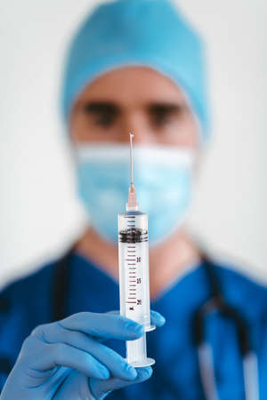 Detail of a doctor's hands putting on gloves with a white backgroundの写真素材