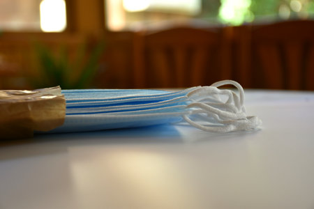 Surgical masks sticking out of a bag in a dining room.