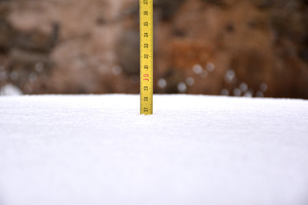 Yellow tape measure measuring snow cover after the storm. Filomena snow storm in La Rioja, Spain, January 2021.の写真素材
