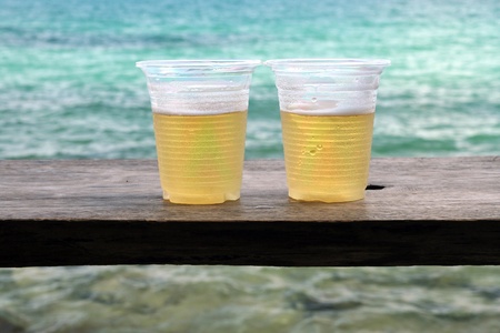 Two glass of beer against sea at same island Thailand の写真素材