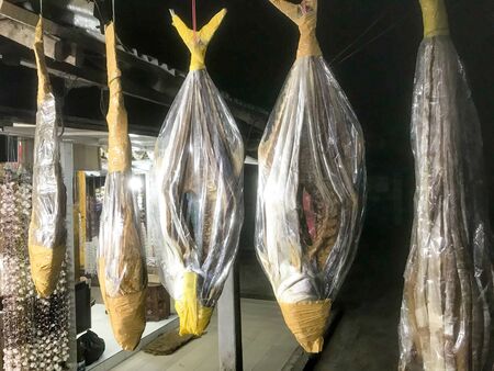 Dried fish hanging in a shop in a marketの写真素材