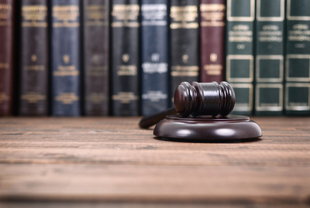 Law and Justice, Legality concept, Judge Gavel on a black wooden background in front of law library.の写真素材
