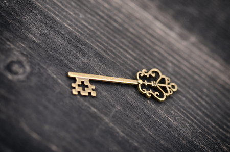 Old vintage key on a wooden background.の写真素材