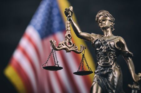 Law and Justice, Legality concept, Scales of Justice, Justitia, Lady Justice in front of the American flag in the background.