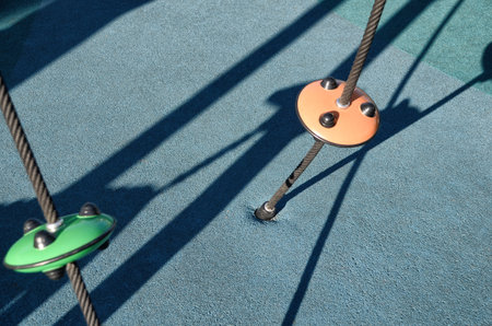 Climbing ropes at kids playground, climbing net, ropes in the playground, jungle gym for climbing kids. Modern playground with colorful rubber flooring for Children.の写真素材