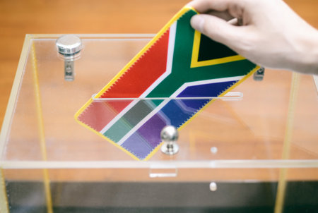 Man inserting Flag of South Africa into ballot box, voting and elections in South Africa.の写真素材