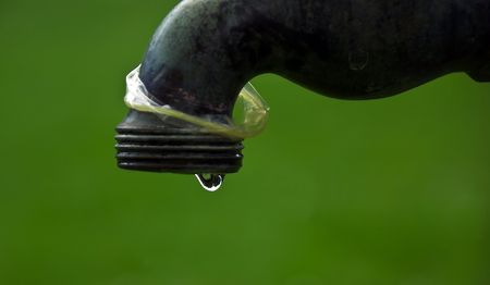 Final drop of water from outside tapの写真素材