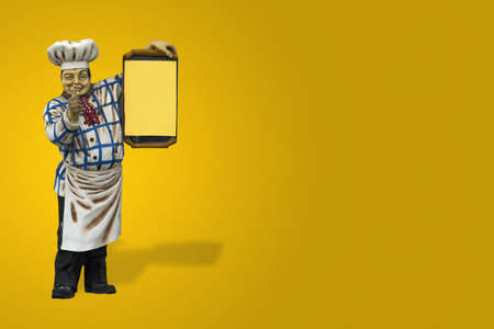 Statue of a man showing the menu from the restaurant.の写真素材